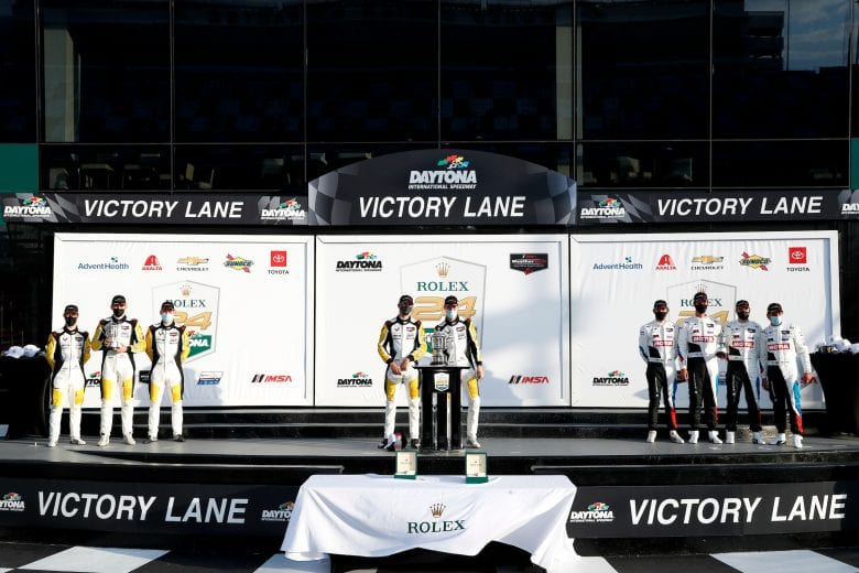 The drivers celebrate their GTLM victory on a socially-distanced victory platform.