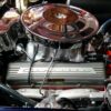 Exposed 1964 L76 engine sitting in blue Corvette with hood open