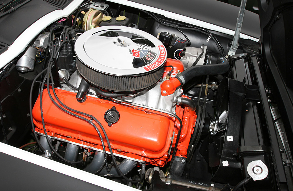 1967 L71 Corvette engine in open hood of black C2 Corvette