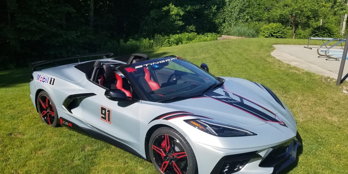 Silver C8 Corvette parked on grass