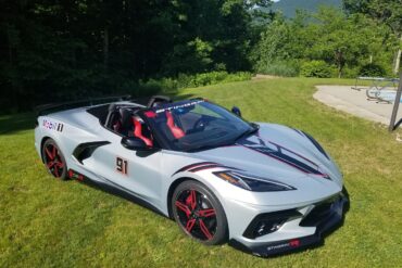 Silver C8 Corvette parked on grass