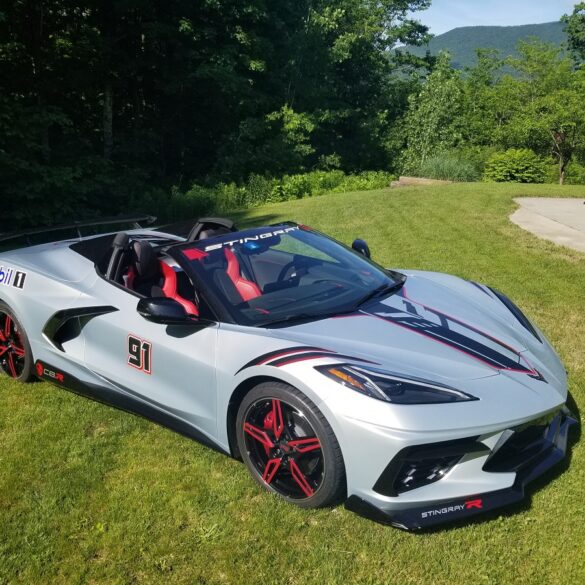Silver C8 Corvette parked on grass
