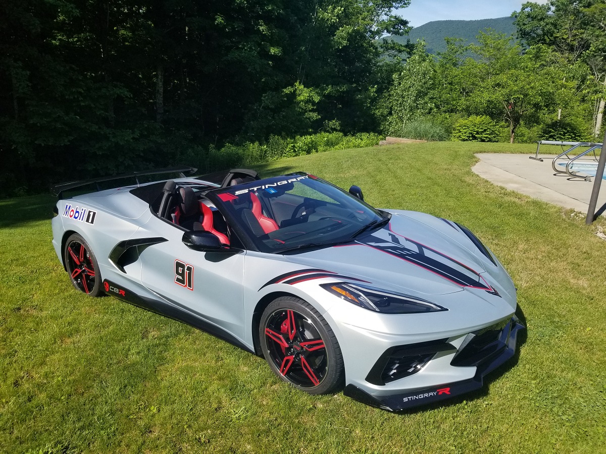 Silver C8 Corvette parked on grass