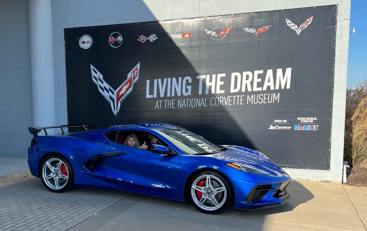 Customers take possession of their new C8 Corvette in front of the Museum delivery mural (which changes from year to year).