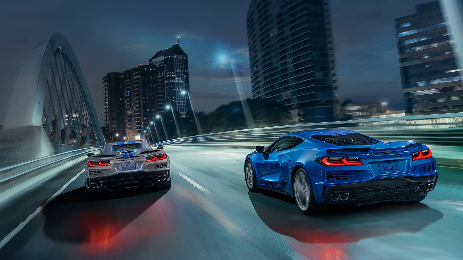 two Corvette E-Rays crossing a bridge at night